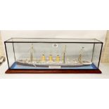 A model of the steam ship Augustia Victoria 1889 in a glass square cabinet standing on a mahogany