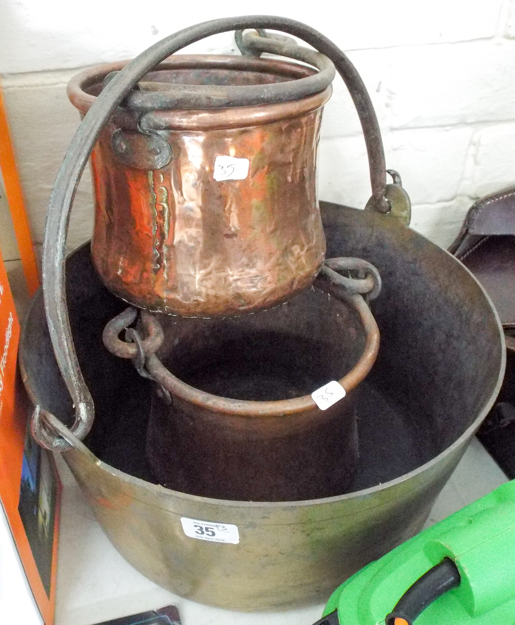A brass preserve pot and two copper pots