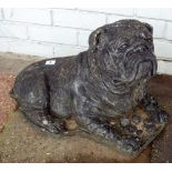 A black painted reconstituted stone garden ornament of a bulldog