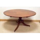 An oval Georgian mahogany snap over top breakfast table on pillar tripod base 57"x38"