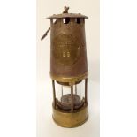 An old brass miners lamp made in Eccles Manchester, serial number 86,