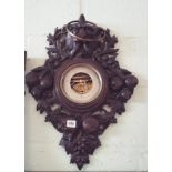 A Victorian Black Forrest style carved oak framed wall barometer decorated with lion mask and fruit