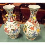 A pair of Chinese dragon and floral decorated polychrome vases with ring handles approximately