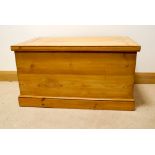 A stripped pine blanket chest with two sliding boxes inside,