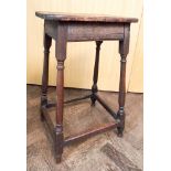 An antique oak stool on turned legs with cross stretchers 25" tall