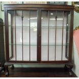 A mahogany bow fronted glazed china display cabinet standing on claw and ball feet 4' wide