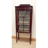 An Edwardian inlaid mahogany china display cabinet standing on square legs,