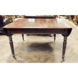 A Victorian mahogany drop leaf dining table standing on reeded legs,