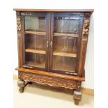 A heavy French oak two door, leaded glazed bookcase standing on carved base with bulbous legs,