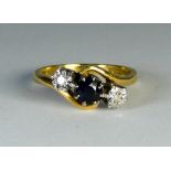 Three stone sapphire and diamond ring, set in a cross-over design on 18ct yellow gold shank,