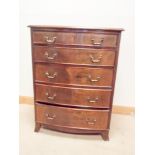 A bow front mahogany chest of five long drawers with brass handles,