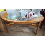 A clover relief shaped teak coffee table with inset glass top