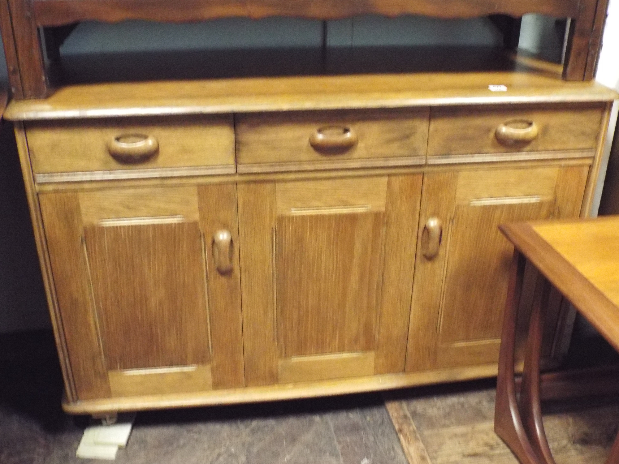 An Ercol light oak sideboard fitted three drawers and three cupboards,