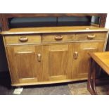 An Ercol light oak sideboard fitted three drawers and three cupboards,