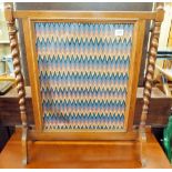 An oak barley twist framed fire screen with needlework panel