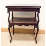 An Edwardian dark mahogany folding top card table with under tier standing on cabriole legs,