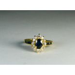 An 18ct yellow gold sapphire and diamond cluster ring with sapphires to the shoulders,