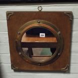 A mahogany framed brass porthole mirror