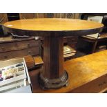 A circular teak topped coffee table on a figured rosewood pillared base,