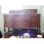 A 1930's oak shaped front sideboard fitted with cupboards and two drawers,