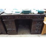 A reproduction mahogany pedestal desk, fitted nine drawers with green leather top,