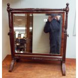 A Georgian beveled swing toilet mirror on a mahogany,