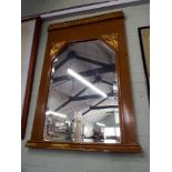 A large bevelled wall mirror in wood effect and gilt decorated frame