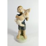 A Royal Copenhagen figure of a boy holding a piglet No.