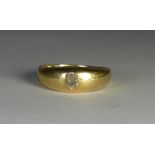 A hallmarked gents 18ct gold band set with an oval diamond, gross weight 7.