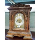 A late Victorian chiming bracket clock in carved oak case with brass and silver dial,