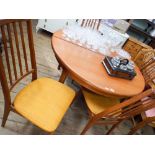 G plan style circular teak dining table and four high slat back chairs with gold upholstered seats