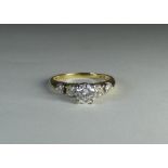 A five stone diamond ring set with a circular brilliant cut diamond in the centre in a raised claw