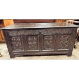 An antique dark oak four panel carved coffer,