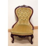 A Victorian walnut framed occasional chair standing on cabriole legs with green button back and