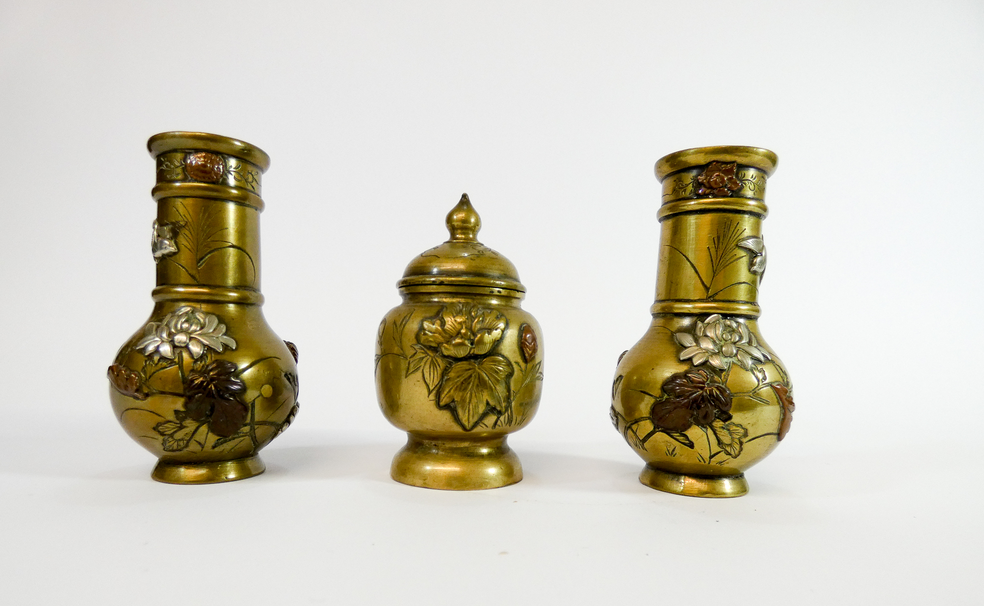 A small garniture of Japanese polished bronze vases and jar and cover,