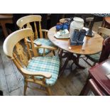 A circular pine single pillar breakfast or dining table together with four light coloured farmhouse