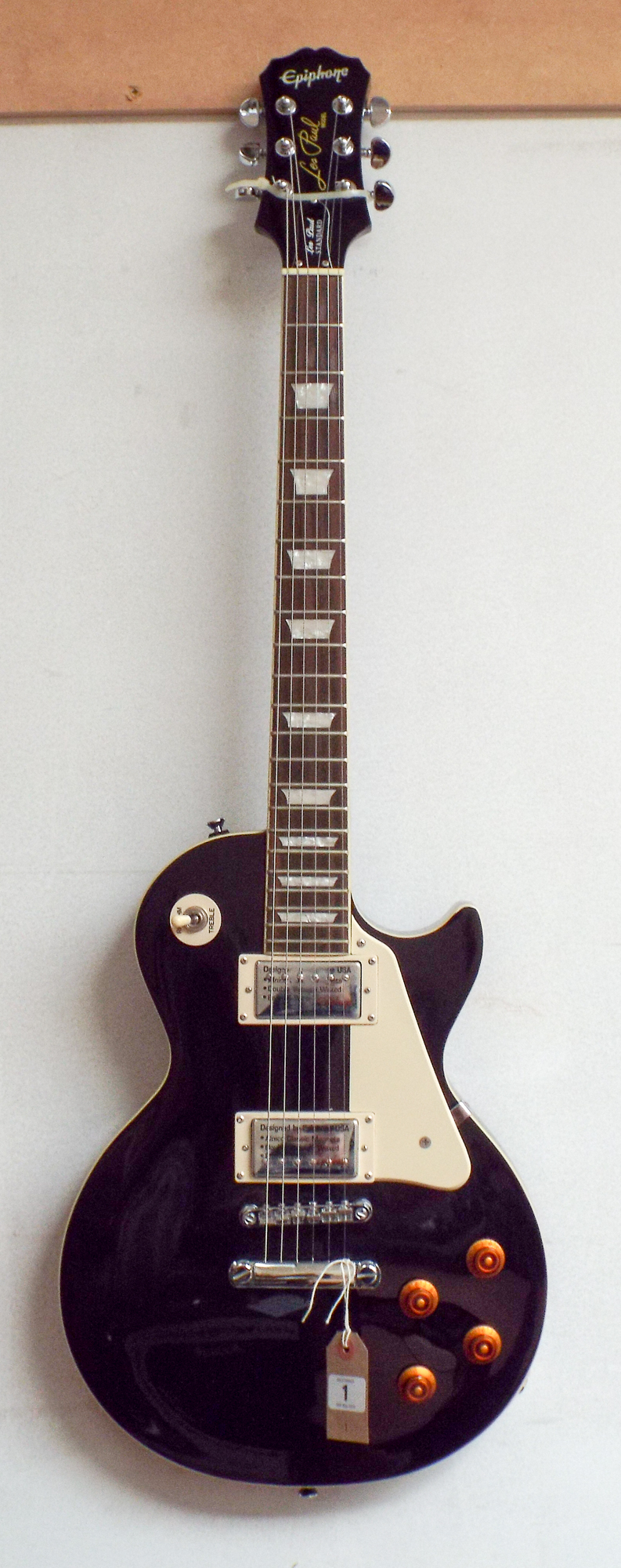 An Epiphone Les Paul model black and cream electric guitar with a mother of pearl inlaid neck with