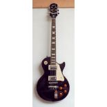 An Epiphone Les Paul model black and cream electric guitar with a mother of pearl inlaid neck with