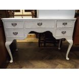 A white painted kneehole dressing table fitted five drawers with brass handles standing on cabriole