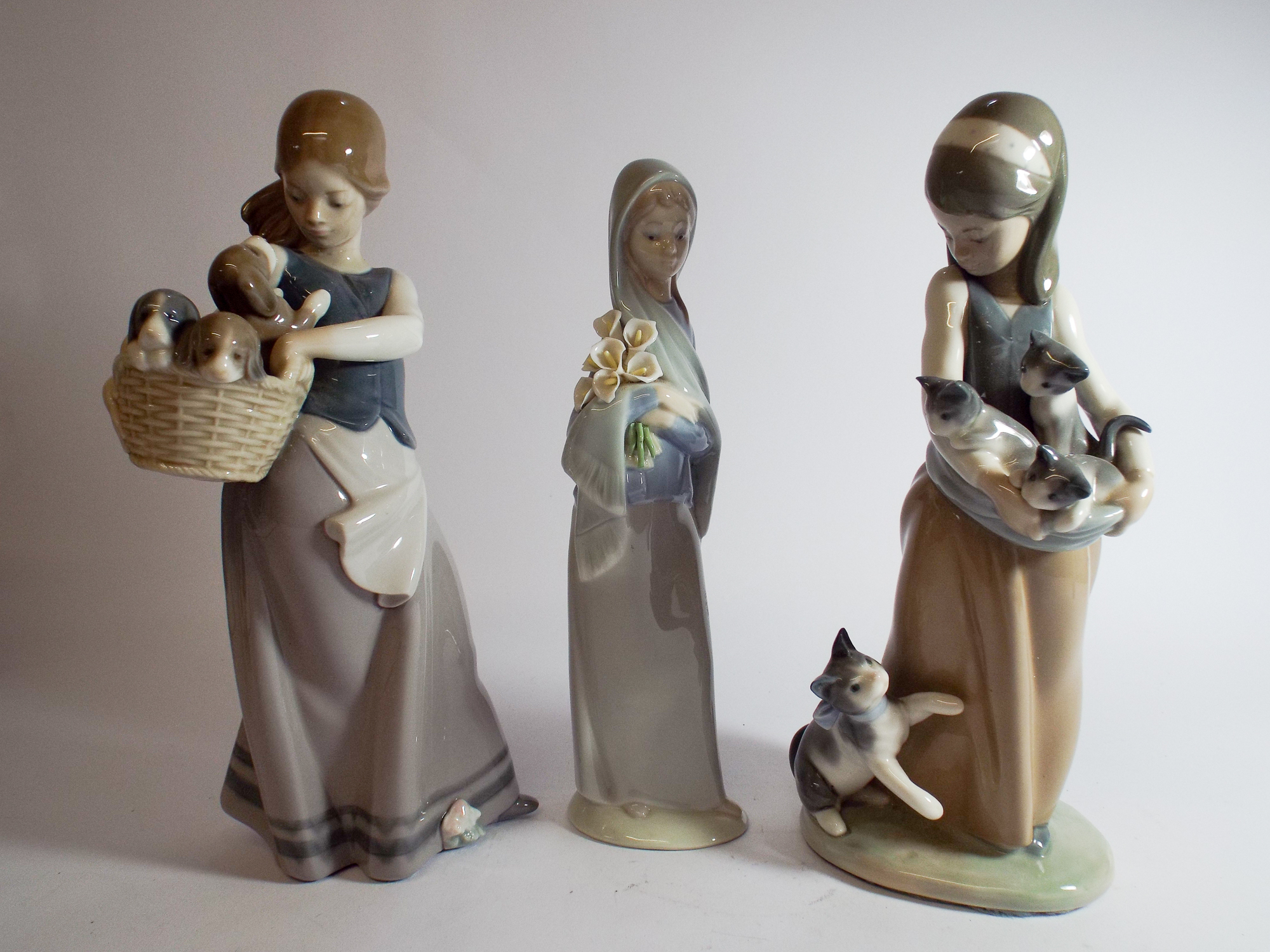 Three Lladro porcelain figurines of girls two holding baskets of puppies and kittens