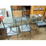 A large glass topped dining table on grey tubular metal base together with six chairs with blue
