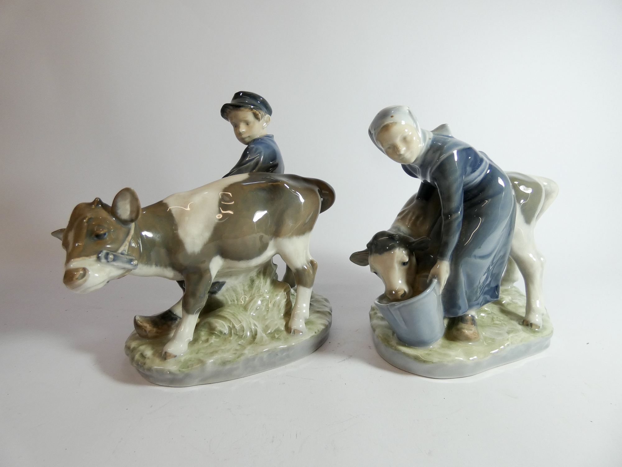 Royal Copenhagen figure of a boy with calf No. 772 and a girl feeding a calf number No.