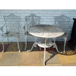 An old painted aluminium circular table with four matching chairs