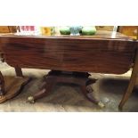 A Georgian mahogany Pembroke table n pillar and quadruple base with brass paw feet 42" wide