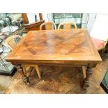 A French walnut parquetry topped draw leaf dining table on turned legs with cross stretchers,