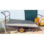 An old metal push-me pull-me trolley with wooden floor,