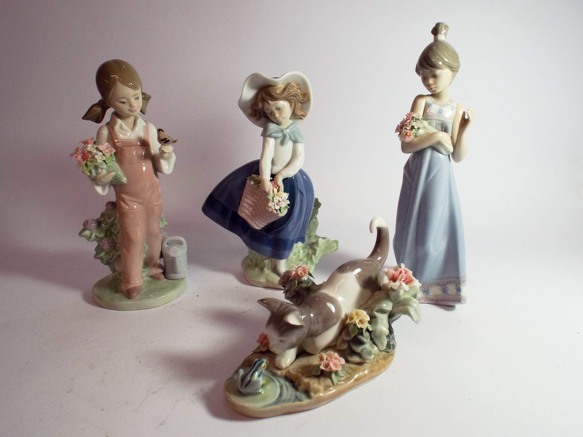 A collection of four Lladro porcelain figurines three girls holding bouquets and one of a kitten