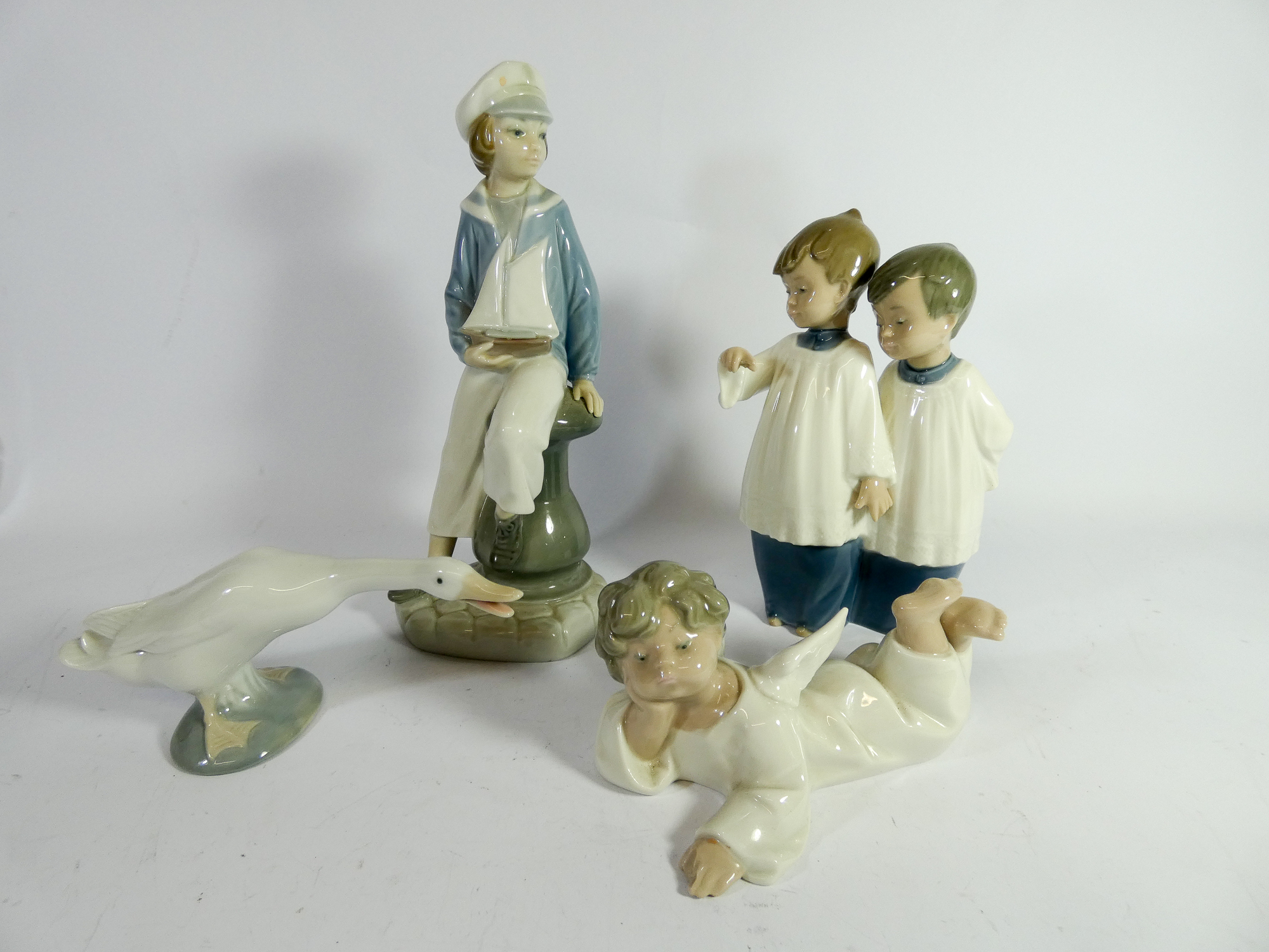 A collection of four Lladro and Nao figurines the largest of which measures 24cm