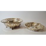 A silver circular sweetmeat dish with pierced edge and a shallow bowl standing on four small