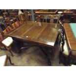 A 1920's mahogany drawer leaf dining table standing on cabriole style legs